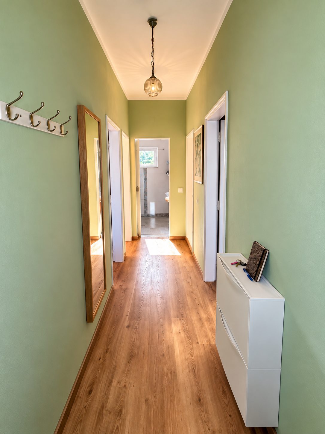 Heller Flur mit grünen Wänden und Garderobe