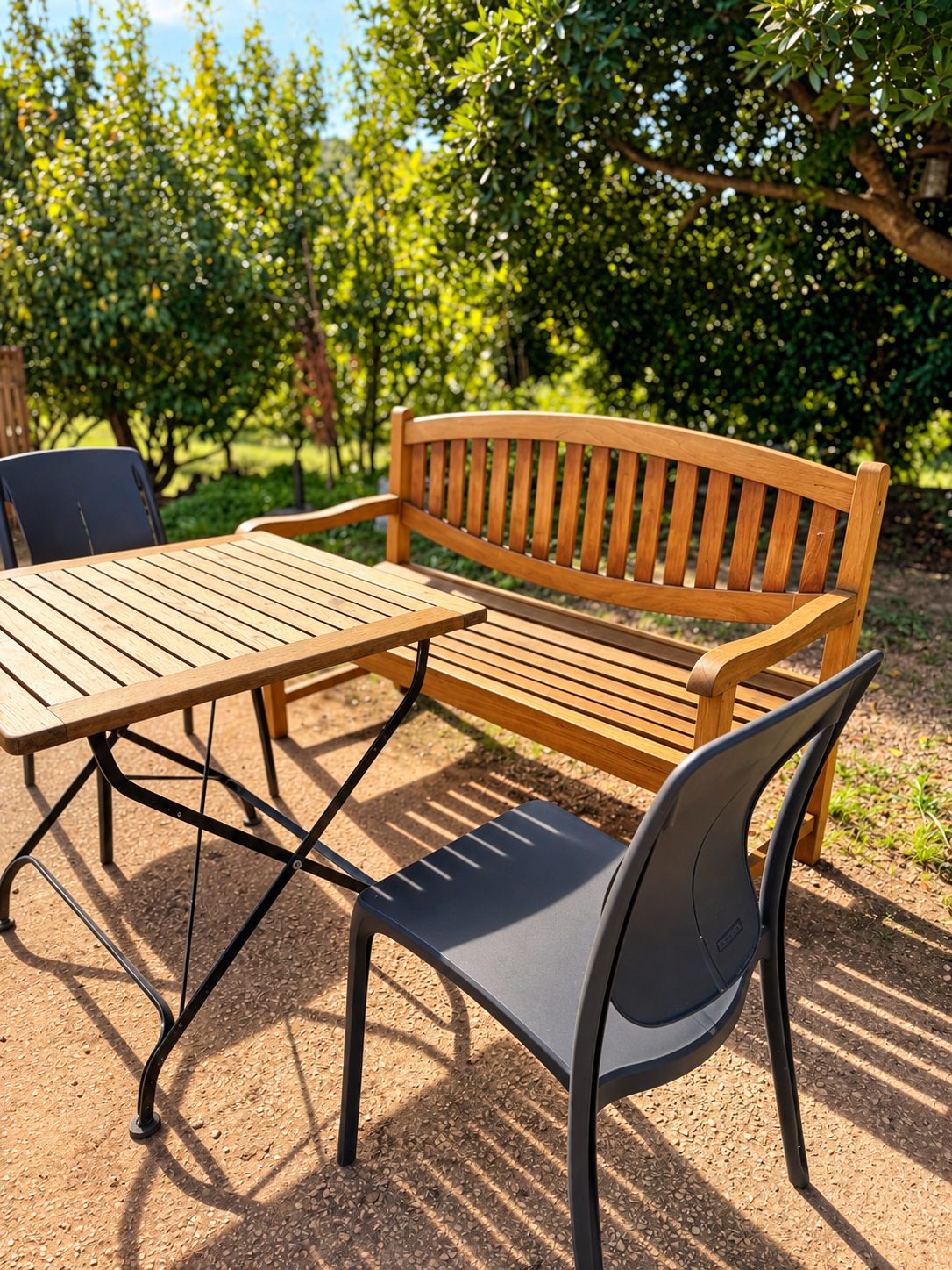 Holzbank und Tisch im Garten unter Bäumen