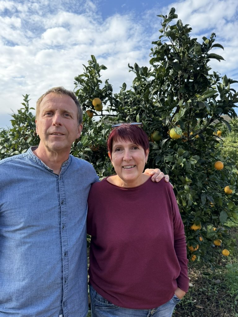 Die Gastgeber vor einem Orangenbaum