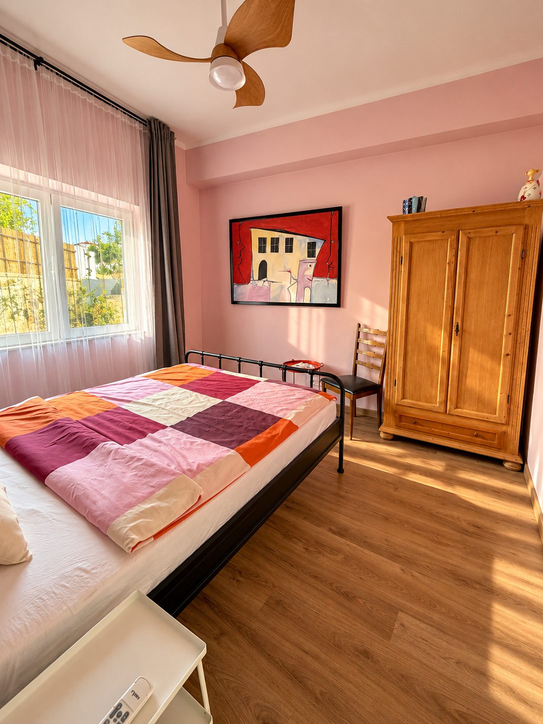 Schlafzimmer mit Doppelbett, Deckenventilator und Holzschrank